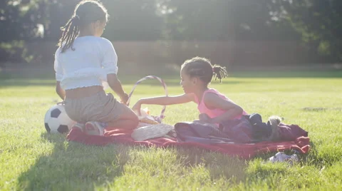 4K Two young children sit down to have a picnic in the sunlight Stock Footage 64750593