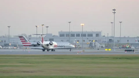 4K UHD - American Eagle CRJ taxiing with airport tower at dawn Stock Footage 46665953