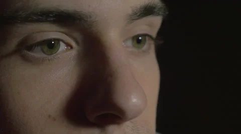 4k UHD - Close-up of a young man eyes in the dark watching TV Video stock 46742194