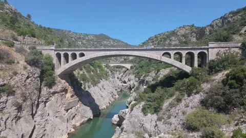 4K UHD drone tracking shot of stone arch bridge over canyon river Stock-Footage 347131459