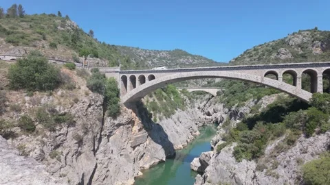 4K UHD dynamic aerial drone shot of stone arch road bridge over river canyon Stock-Footage 347130800
