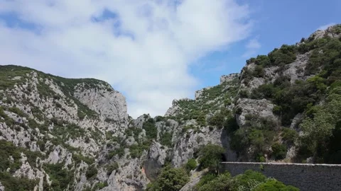 4K UHD dynamic aerial drone reveal shot of rocky green mountain cliffs Stock-Footage 347140385