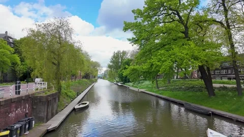 4K UHD dynamic tracking shot of boat navigating Utrecht canal in spring Stockbeeldmateriaal 347200742