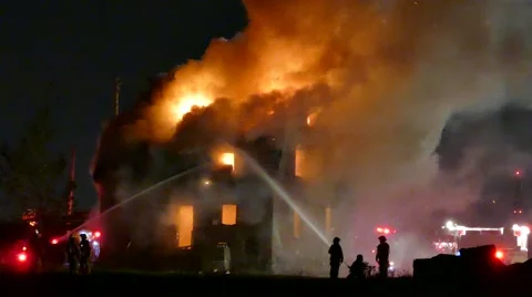 4K UHD - Firemen putting water on fully involved house fire Stock Footage 50560352