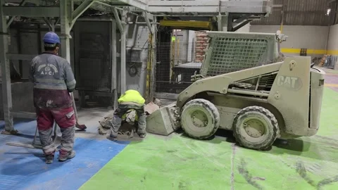 4K UHD: Industrial Workers and CAT Skid Steer Cleaning Cement Factory Floor 動画素材 332015002