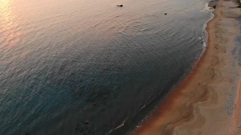 4k UHD realtime 45 degrees aerial view of waves motion over orange sand coast Stock Footage 105356460