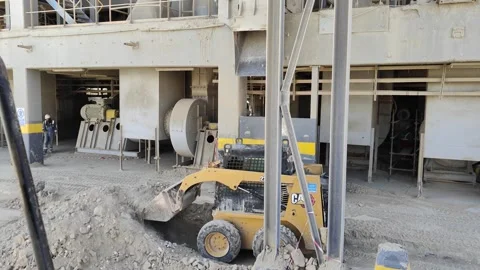 4K UHD Skid steer loader clearing debris inside a cement factory Vídeos de archivo 335620107