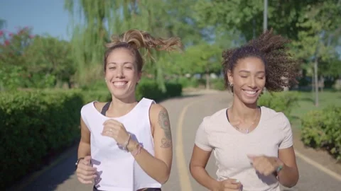 4K UHD slow-motion close up of two mixed-race female happy runners training a Stock Footage 144387406