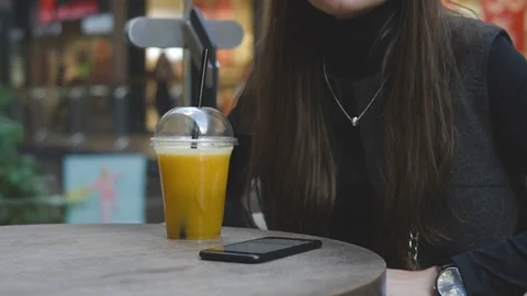 4k UHD Slow Motion. Young woman browsing on mobile phone in cafe drinking juce Stock Footage 78758818