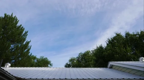 4K UHD Timelapse of clouds moving over the roof of a house. Stock Footage 53980420