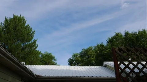 4K UHD Timelapse of clouds moving over the roof of a house. Stock Footage 53982043