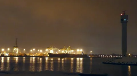 4K UHD - Wide shot of commercial port at night in winter with cargo ship Stock Footage