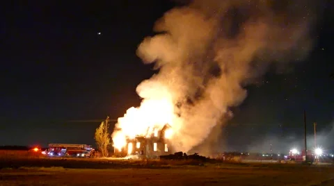4K UHD - Wide view of bright house fire with airplane  Stock-Footage 50560807
