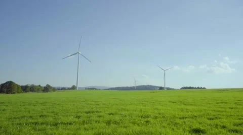 4K UHD Windmill park on grassy field with blue sky Video stock 65235697