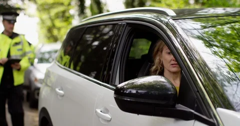 4K UK Traffic cop talking to female motorist after pulling her over for a violat Stock Footage 113130637