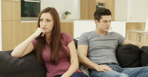 4K Unhappy & annoyed couple at home ignoring each other after an argument Stock Footage
