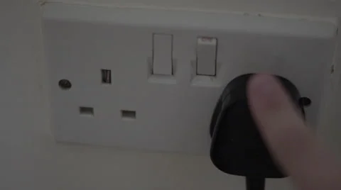 4K Unplugging a british black electric plug from a white wall socket Stockbeeldmateriaal 51833474