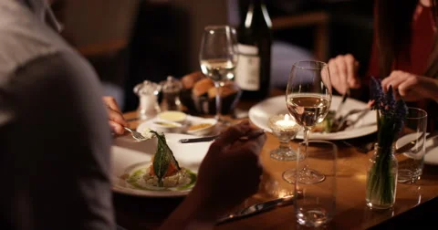 4K Unrecognizable couple on a date in restaurant chatting as they enjoy their me Stock Footage 62884445
