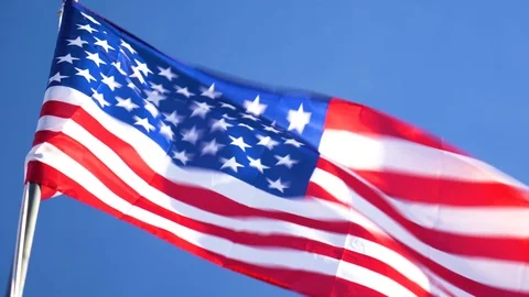 4K US Flag Blows in the Wind Blue Sky in Background Stock Footage 100272579