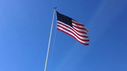 4K US Flag Waving On Flagpole Against Clear Blue Sky Background Stock-Footage 334460778