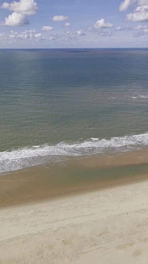 4K Vertical Aerial View of Waves Crashing on Rotterdam North Sea Beach Stock Footage 344742215