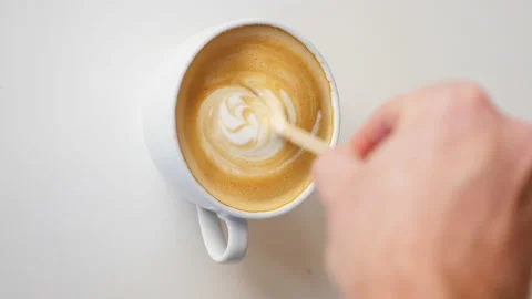 4K VERTICAL, Coffee Stir Reverse Effect to Reveal Milk Design, Close Up Stock Footage 239409865