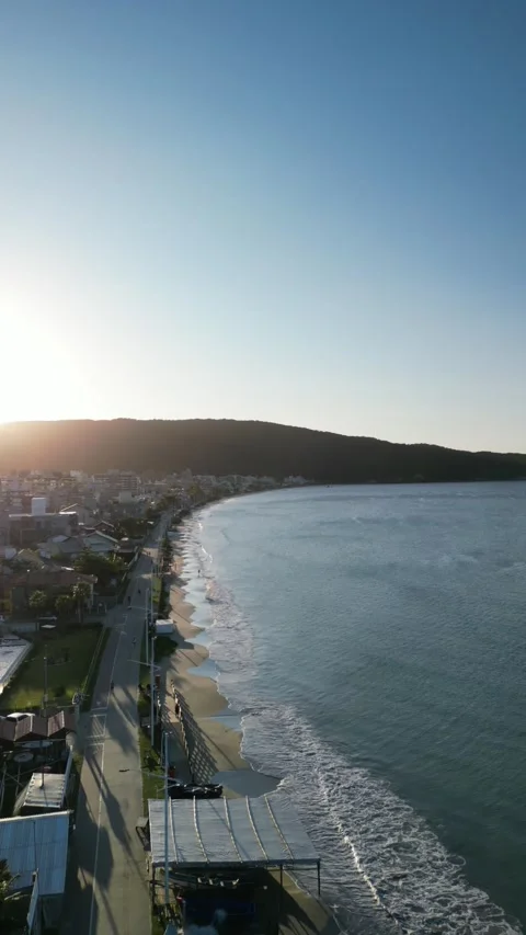 4K Vertical Drone Flyover of Sunset Beach with Cityscape Stock Footage 311553245