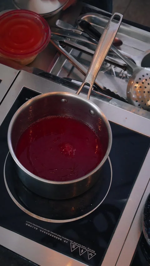 4K vertical overhead video chef stirring balsamic raspberry sauce in pan Stock Footage 315395421