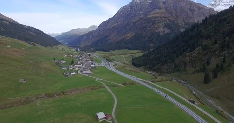 4k vertical pan view of vast mountain valley tracking up flight over local town  Stock Footage 93373836