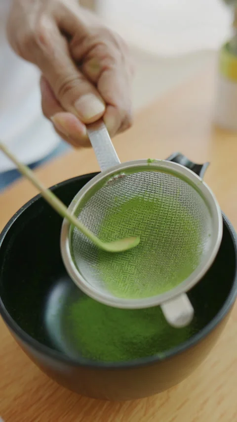 4K Vertical shot preparing matcha green tea powder by sifting before whiskin Stock Footage 340996319