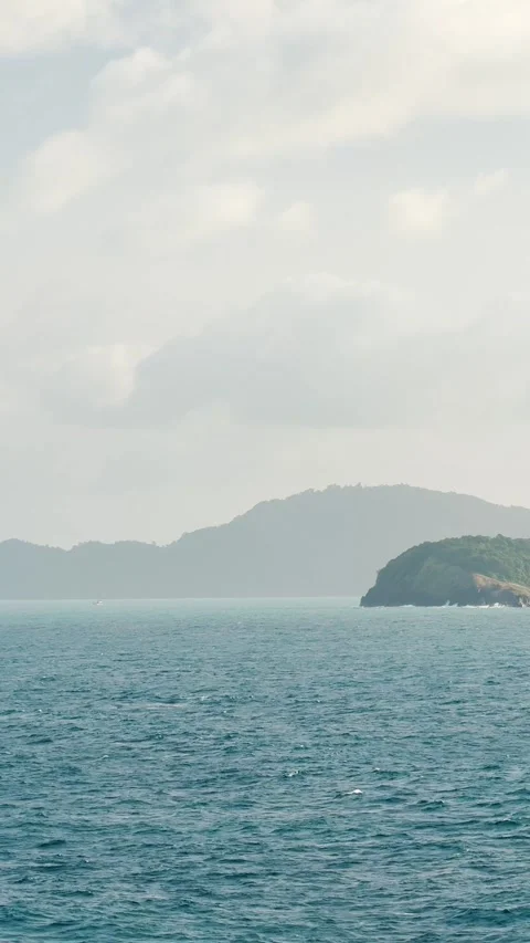 4K Vertical shot of sea in front of Phuket islands with clouds in the sky  Stockbeeldmateriaal 323315119