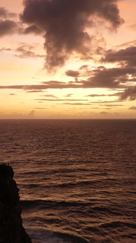 4K vertical sunset over ocean horizon with a silhouette on a cliff 스톡 동영상 337085454