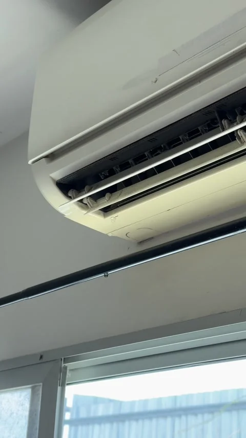 4K vertical video of a broken air conditioner unit leaking water onto a curtain  Stock Footage 342777133
