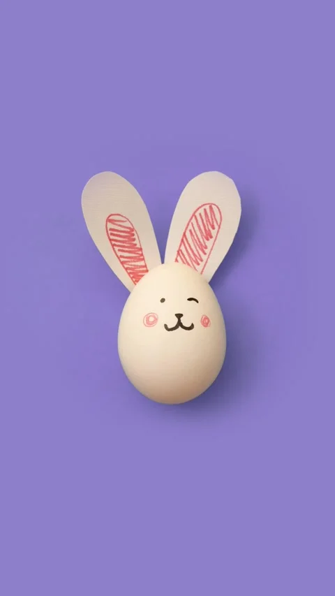 4K vertical video. Easter egg with cute bunny face on purple background Stock Footage 270255750