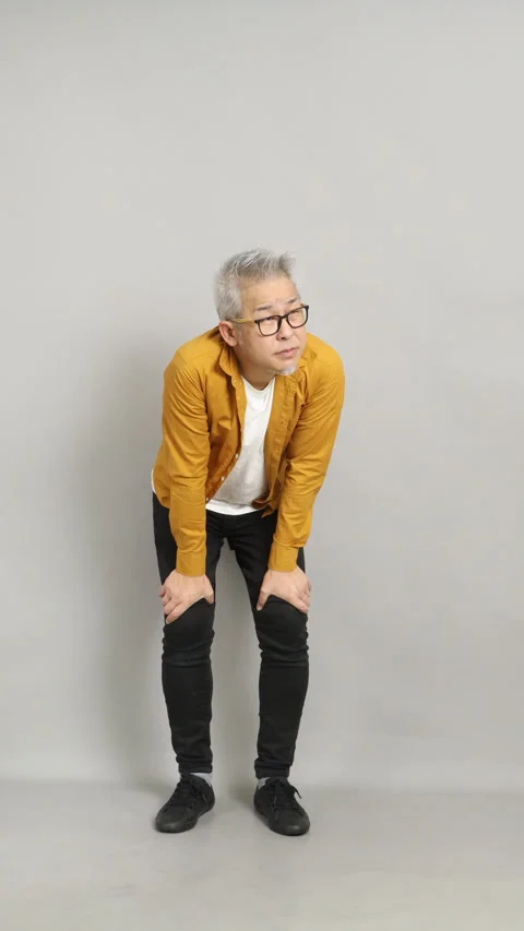 4K vertical video of an exhausted mature man holding his knees and gasping for a Stock Footage 332858031