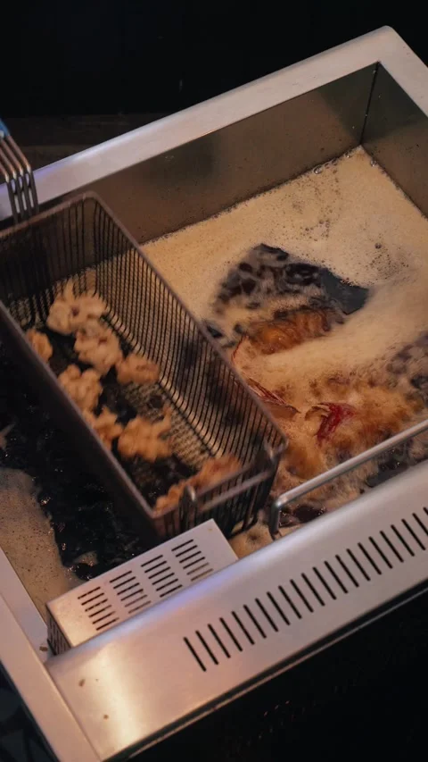 4K vertical video red snapper frying in deep fryer – overhead shot Stock Footage 315395527