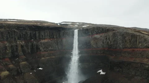 4K Very Large Waterfall surrounded by Red-Layered Rocks Stock Footage 145749981