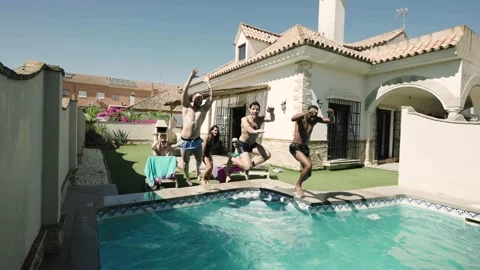 4K video of 3 friends jumping into a pool in summer Stock Footage 219967708