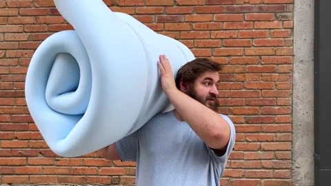4K video. 60 fps. Mature man holds blue foam rubber for cheap furniture Stock Footage 341275280