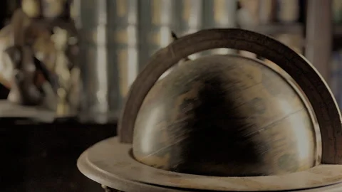 4K video of antique globe spinning in library Stock Footage 340030586