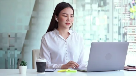 4k video of Boost mood at work. Joyful asian woman listening music Stock Footage 125988302