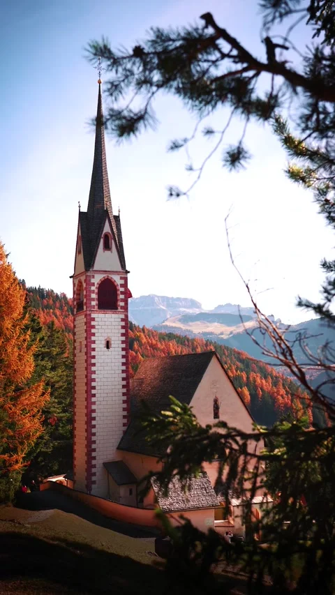 4k video of a Charming alpine chapel in a mountain meadow surrounded by pines Stock Footage 292710121