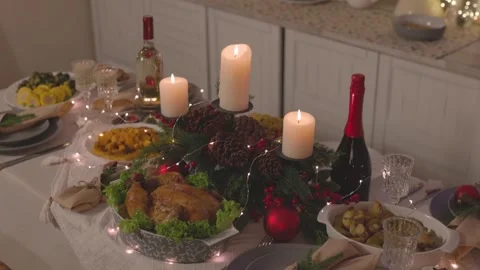 4K Video of Christmas Dinner Table with Pinecones, Candles, and String Lights Stock Footage 324562915