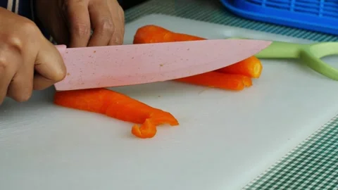 4k video clean the carrot bones and cut the carrots on a board. Stockbeeldmateriaal 294195655