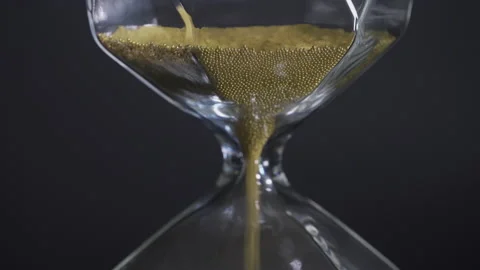 4K video Close up of falling sand in sand clock on black background. Concept  Stock Footage 155136152