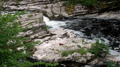 4K video of a close up of small waterfall and rocky river bank Stock Footage 132143251