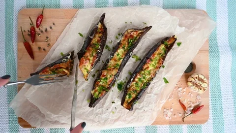 4k video cut the halves of stuffed eggplant on a wooden board Stock Footage 155475602