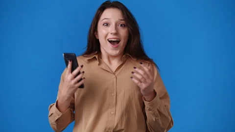4k video of cute girl using phone over blue background. Stock Footage 241034348