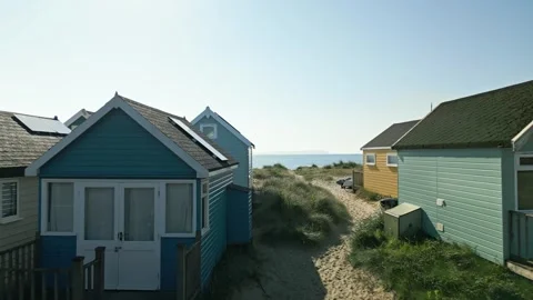 4k video of drone flying through beach huts towards beach and sea in Mudeford Stock Footage 278103653