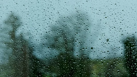 4K video footage of rain from inside a car window with a blurred background Stock Footage 276673948